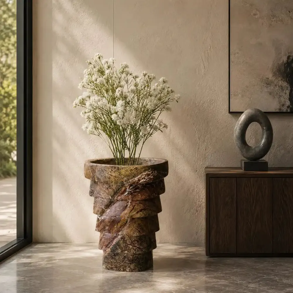 Spiral-carved solid stone planter holding white flowers